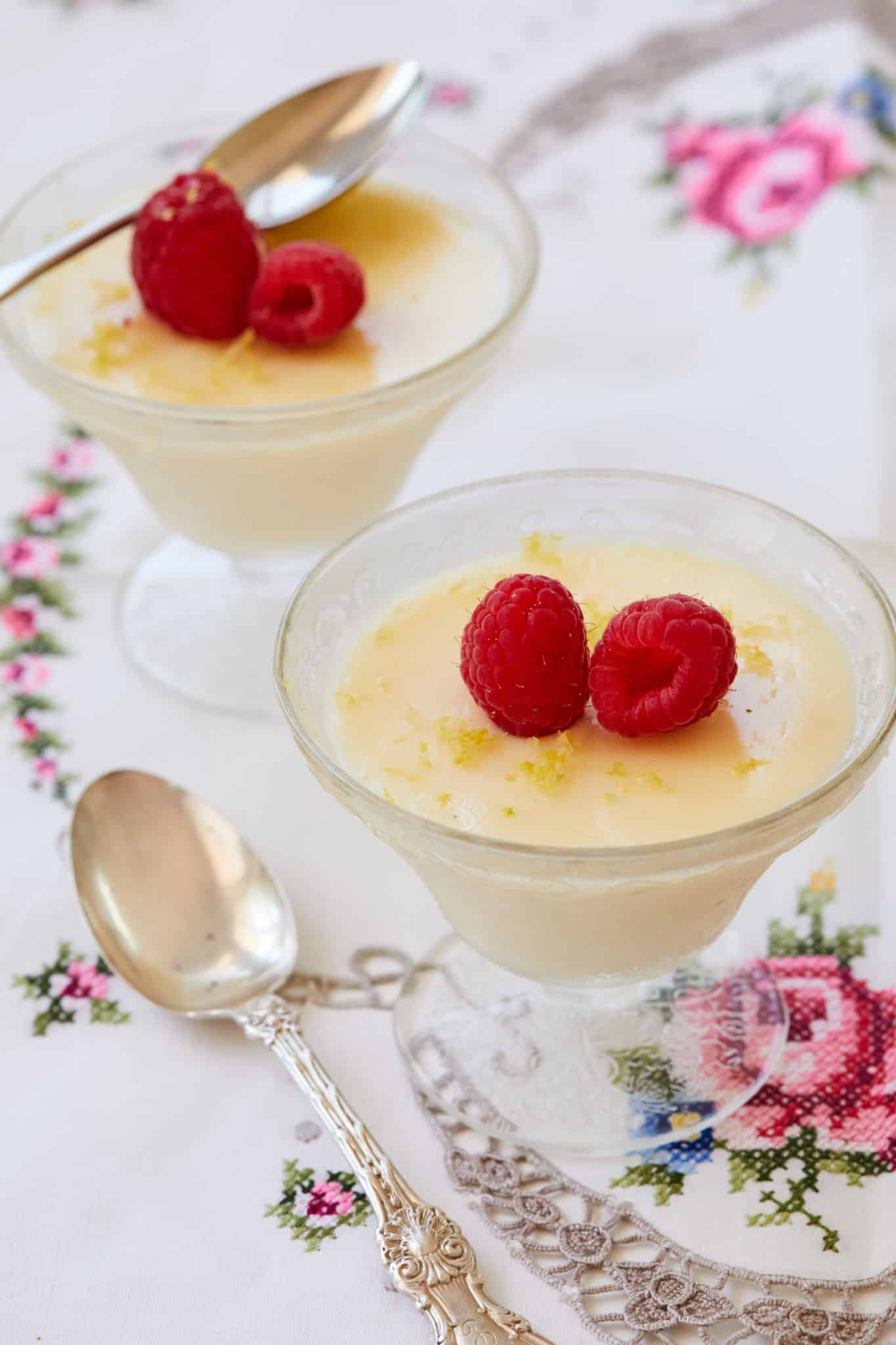 Two glasses of Lemon Posset topped with raspberries