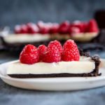 A slice of panna cotta tart topped with raspberries