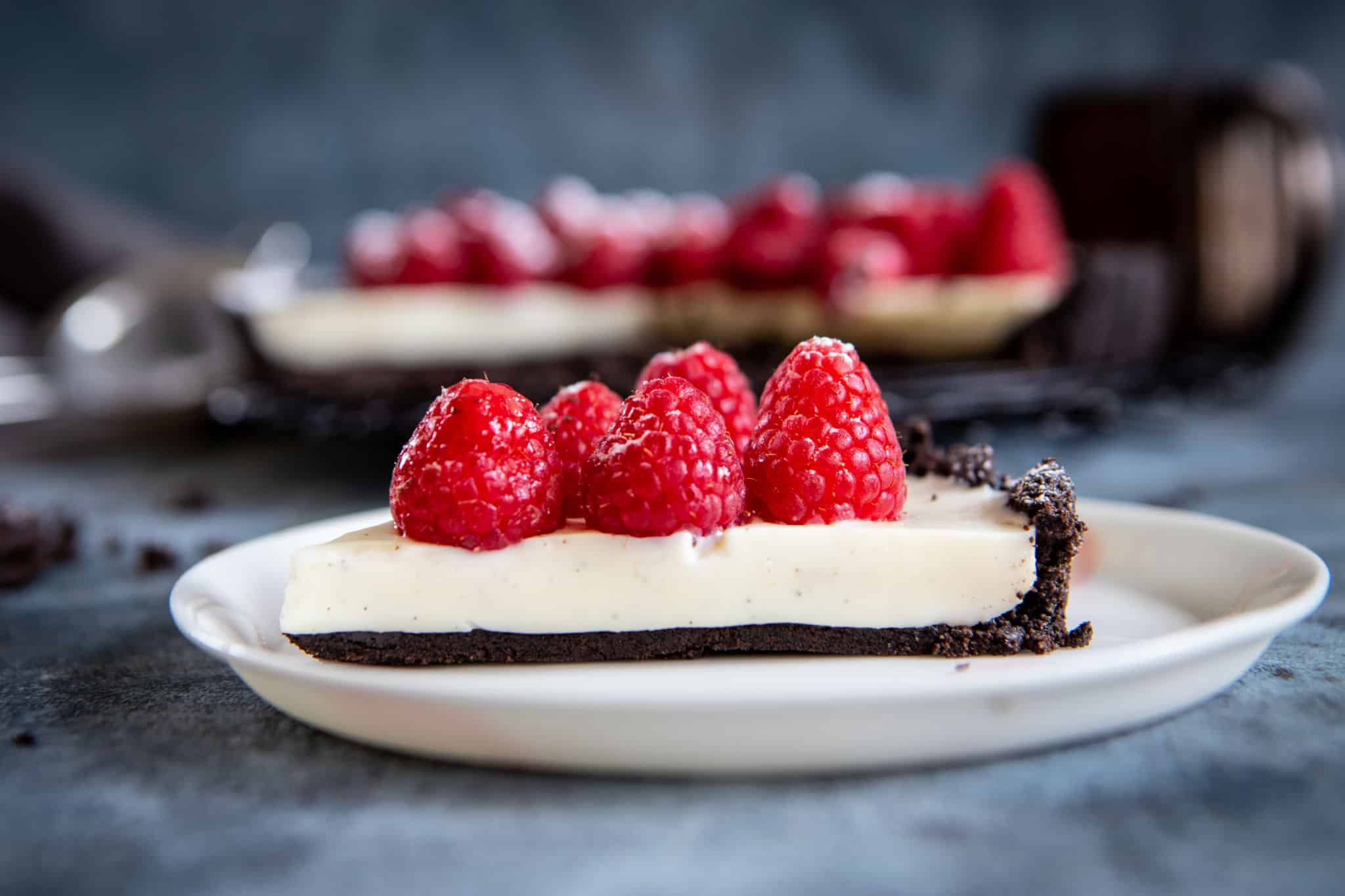 A slice of panna cotta tart topped with raspberries