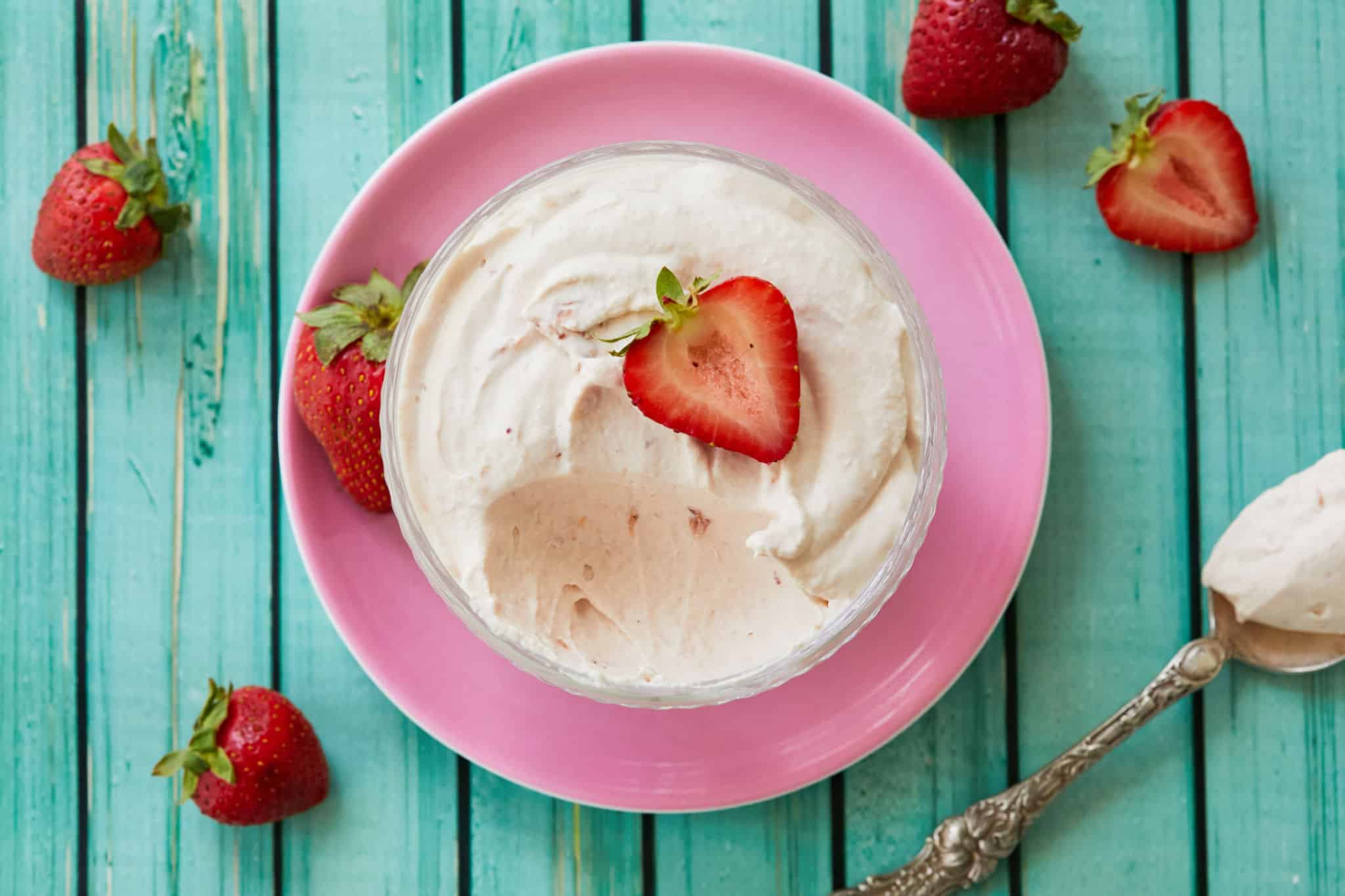 Strawberry Whipped Cream in a bowl with a strawberry on top.