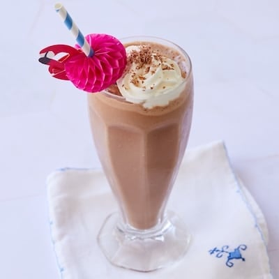 Chocolate Malt served in a tall glass with whipped cream on top.