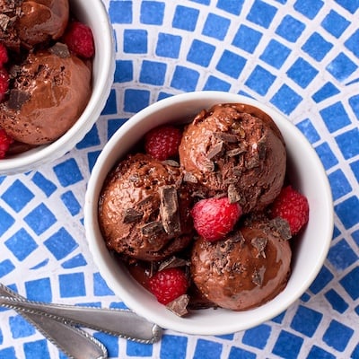 Healthy banana chocolate ice Crean is served with raspberries and chocolate chunks.