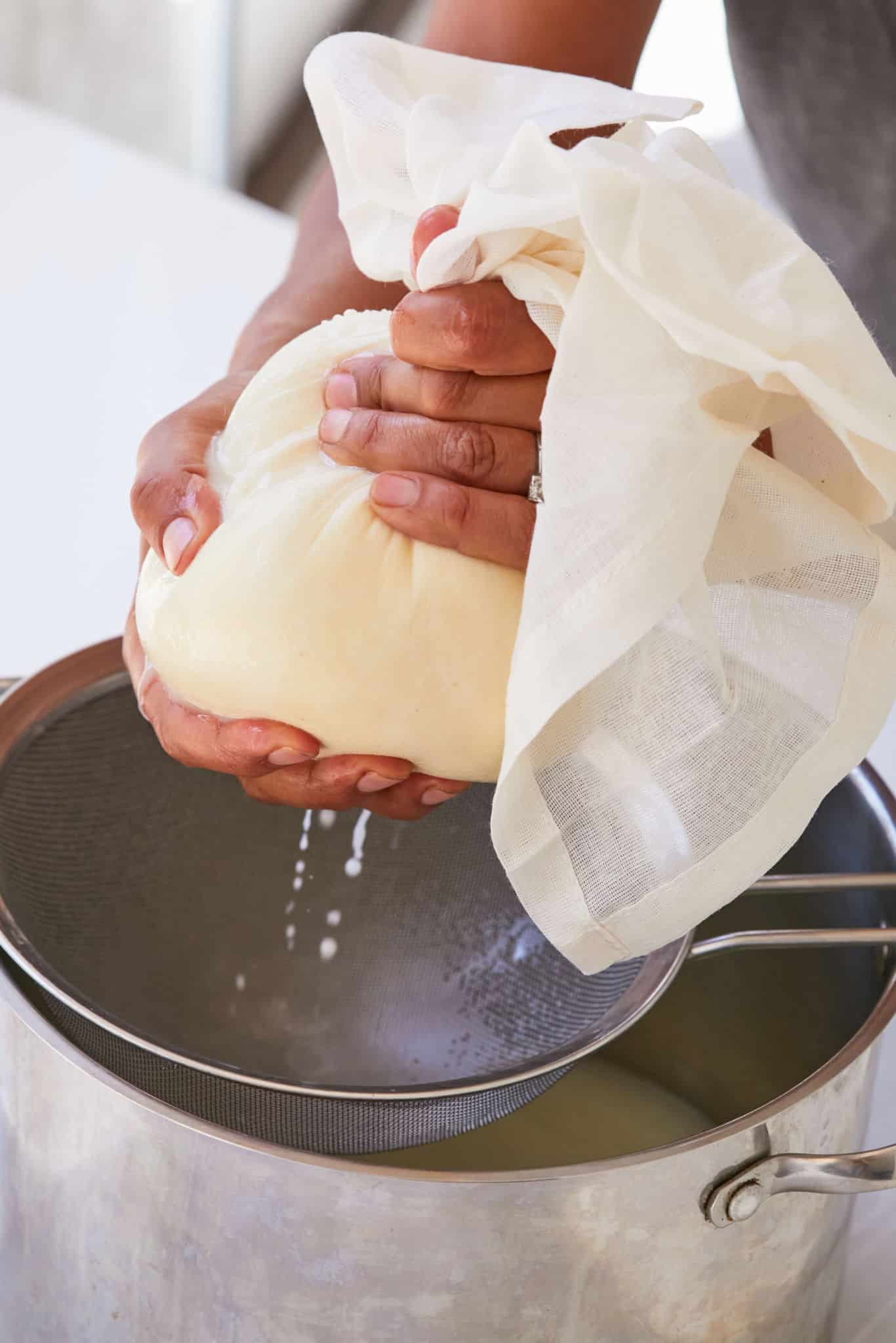Firmly press on the curds to squeeze out as much whey as possible, using the cheesecloth to help squeeze.