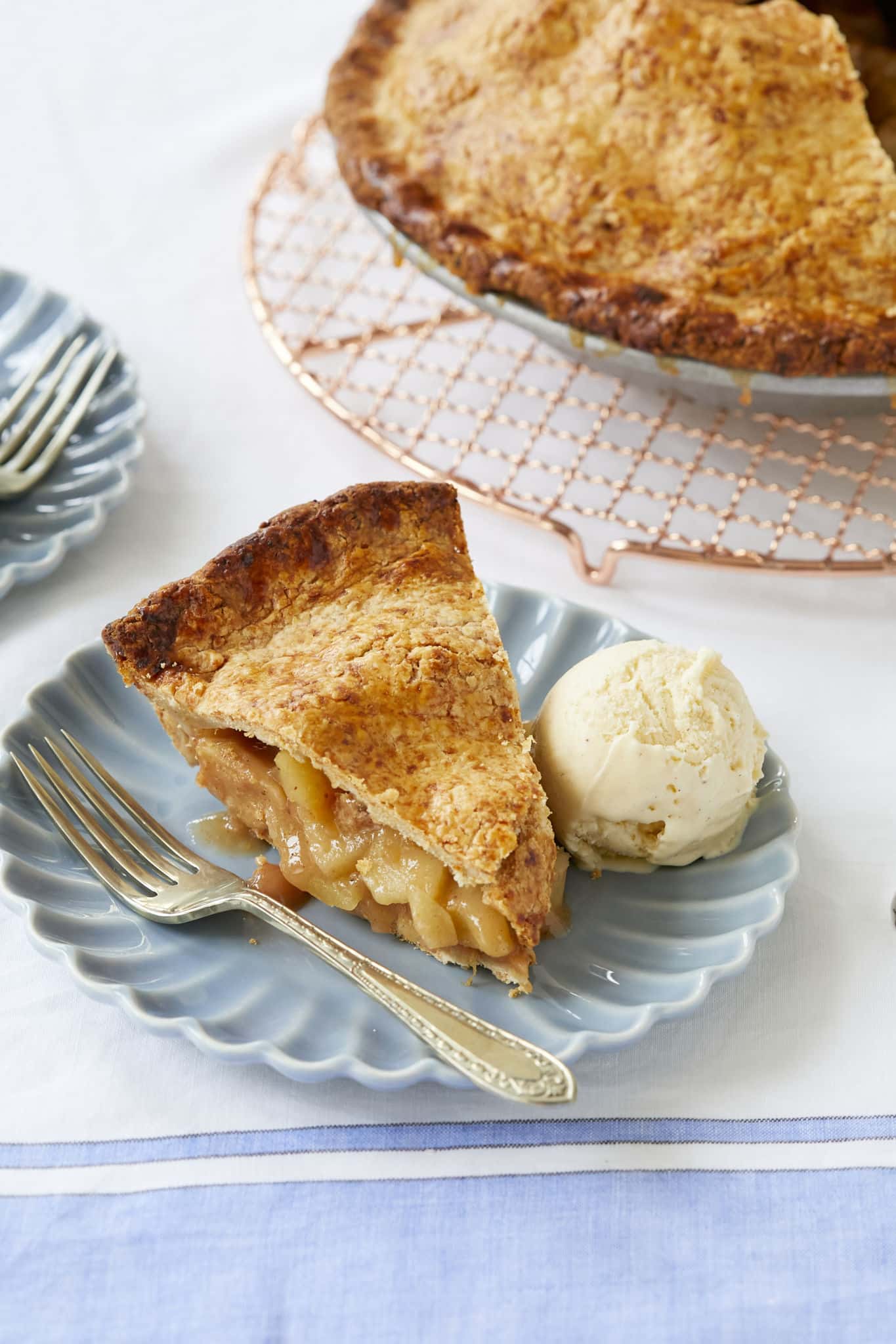 Warm apple pie filling is topped with a buttery crust, flecked with cheddar cheese.