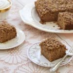 Homemade apple snack cake is cut into separate servings. The apple cake has a crumbly streusel topping.