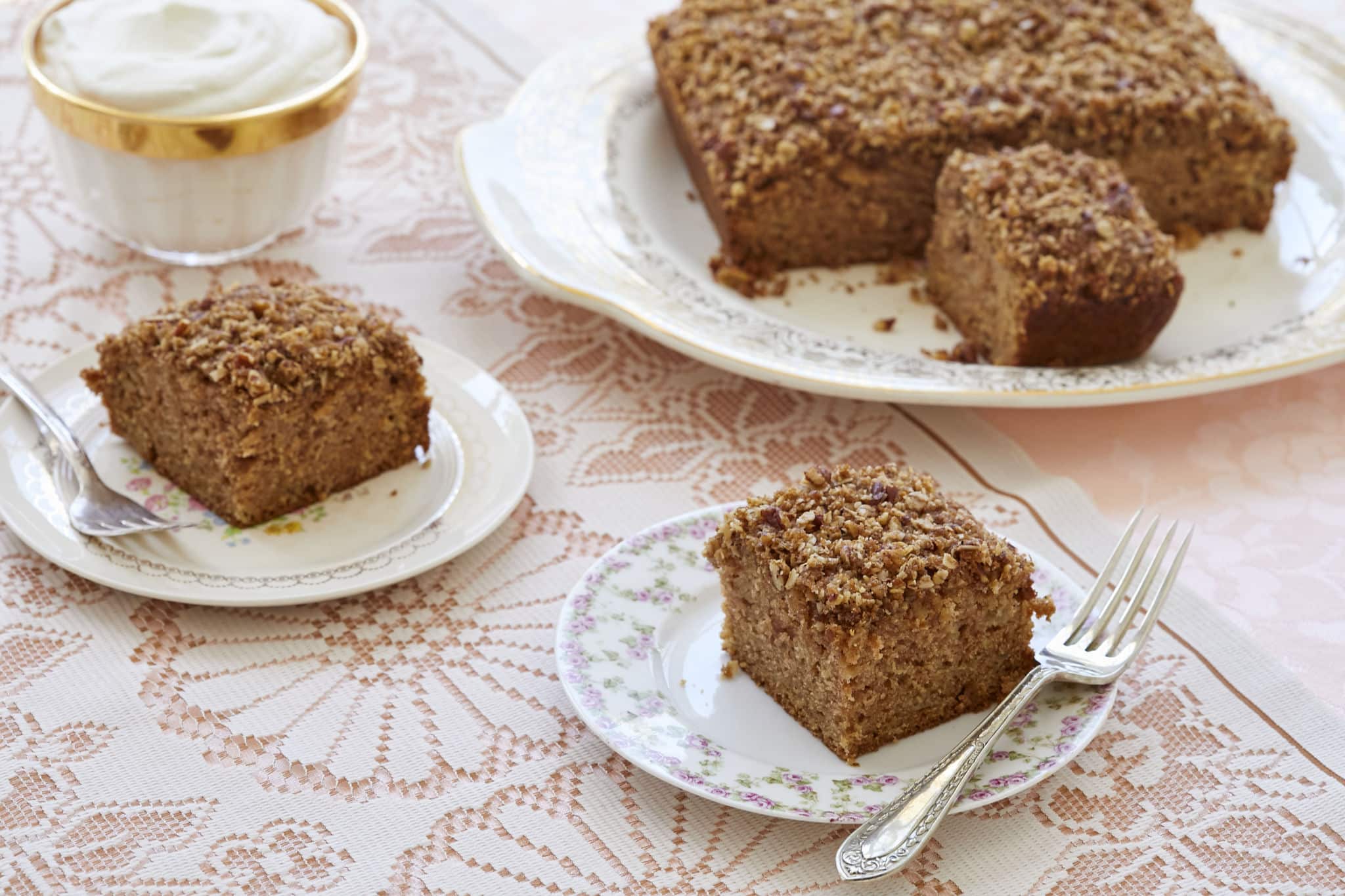 Homemade apple snack cake is cut into separate servings. The apple cake has a crumbly streusel topping.
