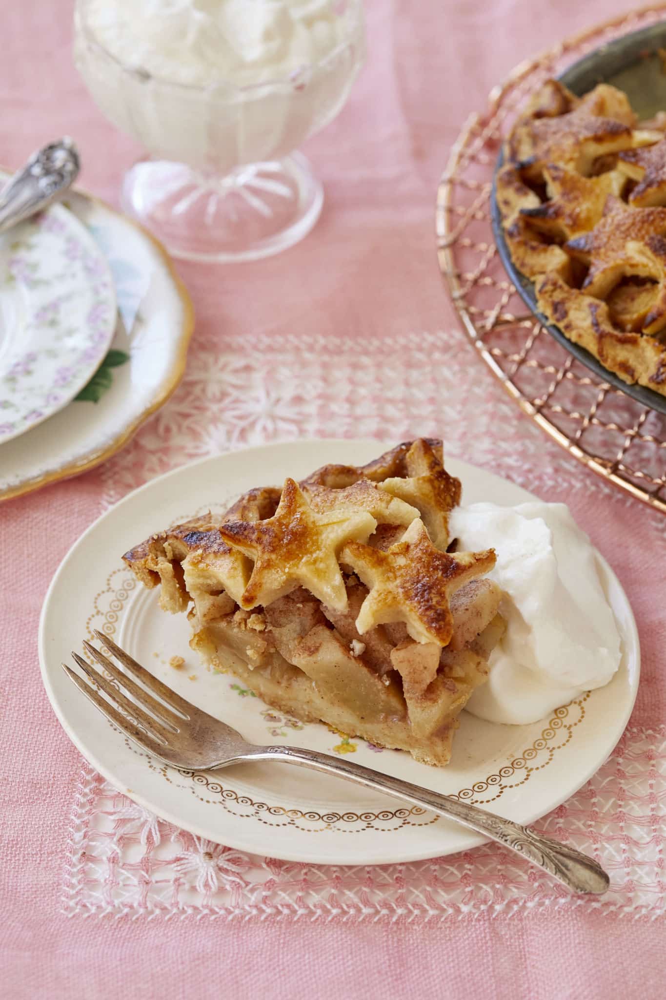 A slice of butterscotch pear pie. The pie's filling is baked pear with spices. It is served with homemade whipped cream.