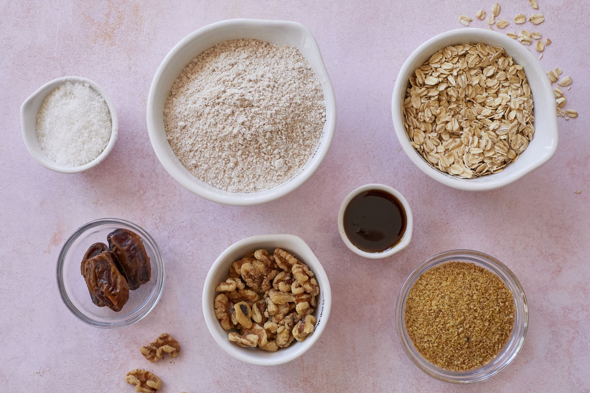 Healthy baking ingredients are displayed on a table, including dates, oats, and almond flour.