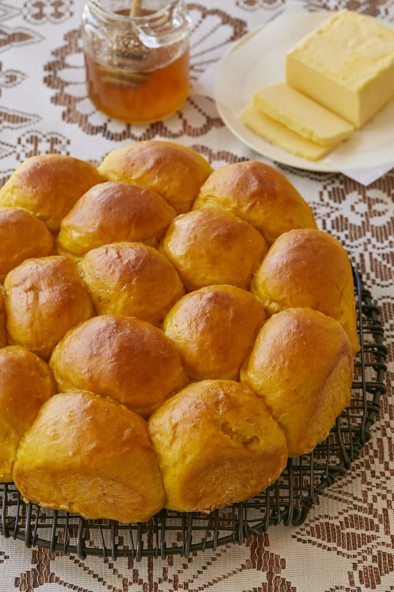 A closeup image of the pumpkin dinner rolls show how they have baked together. They are golden brown all over.