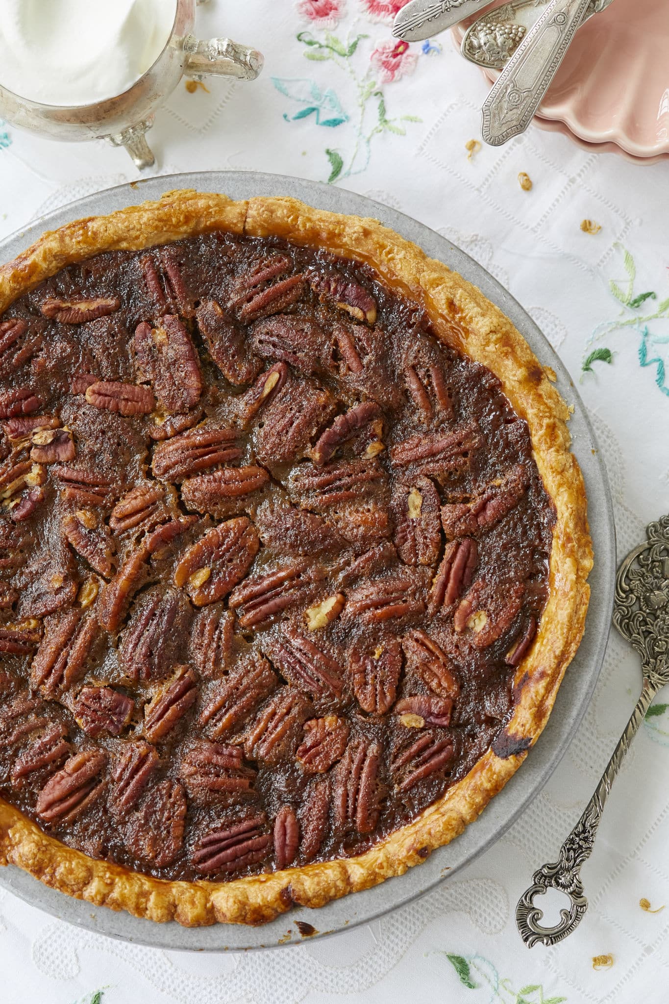 A close-up image, shot from above, of the pumpkin pecan pie. The pie crust is golden brown and the top layer of the pie is covered in pecans.
