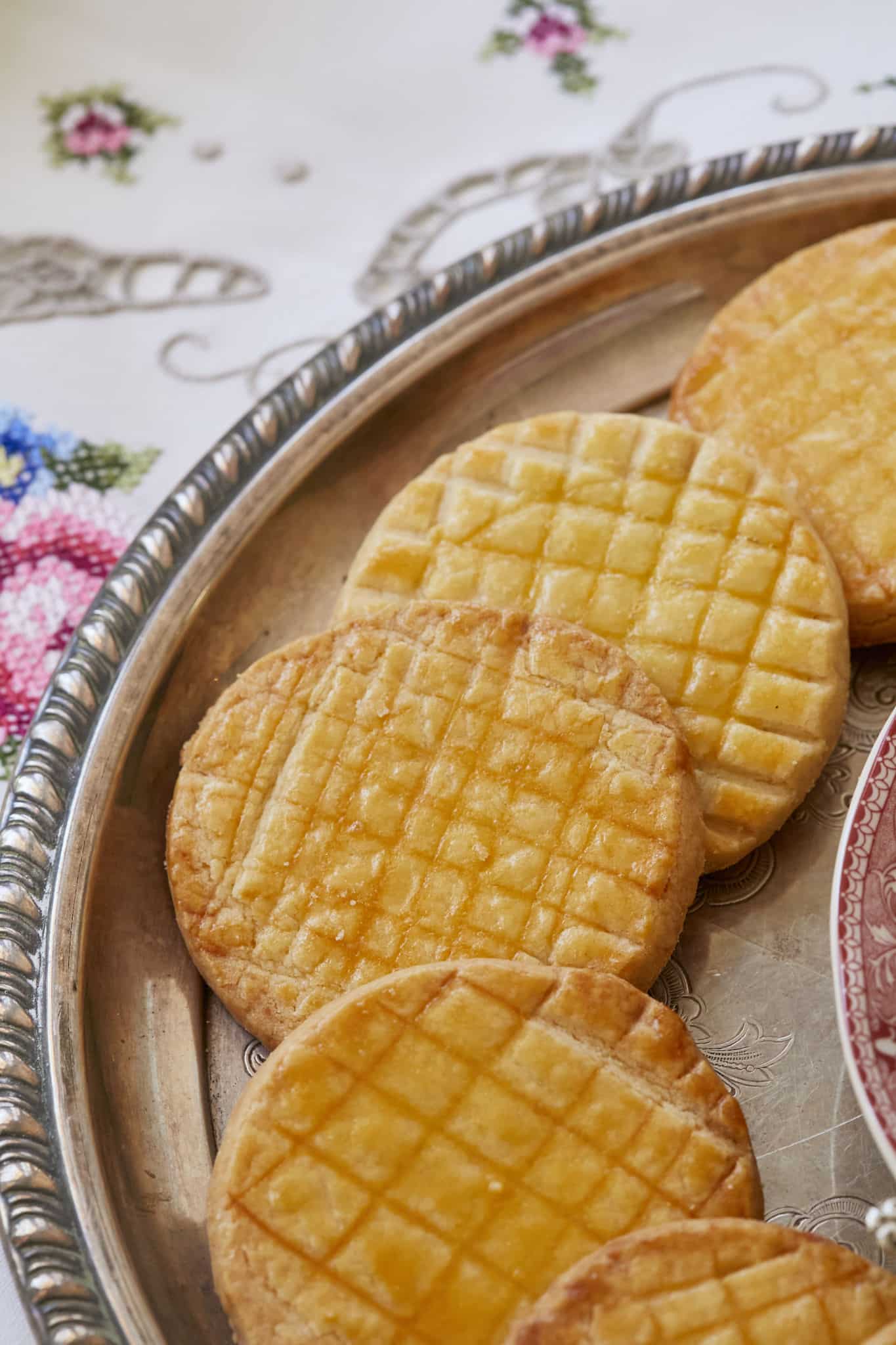 A close-up photo of homemade French Sable Cookies show a crosshatch design. The cookies are golden brown.