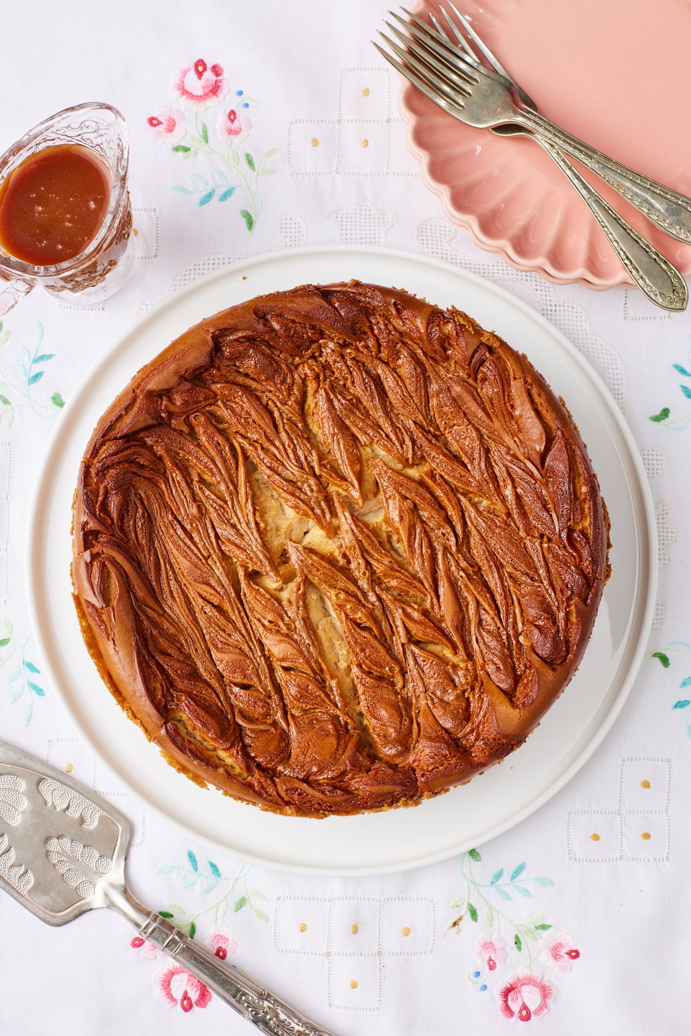 Caramel Apple Cheesecake16 Top down view of a whole caramel apple cheesecake with caramel sauce on the side.