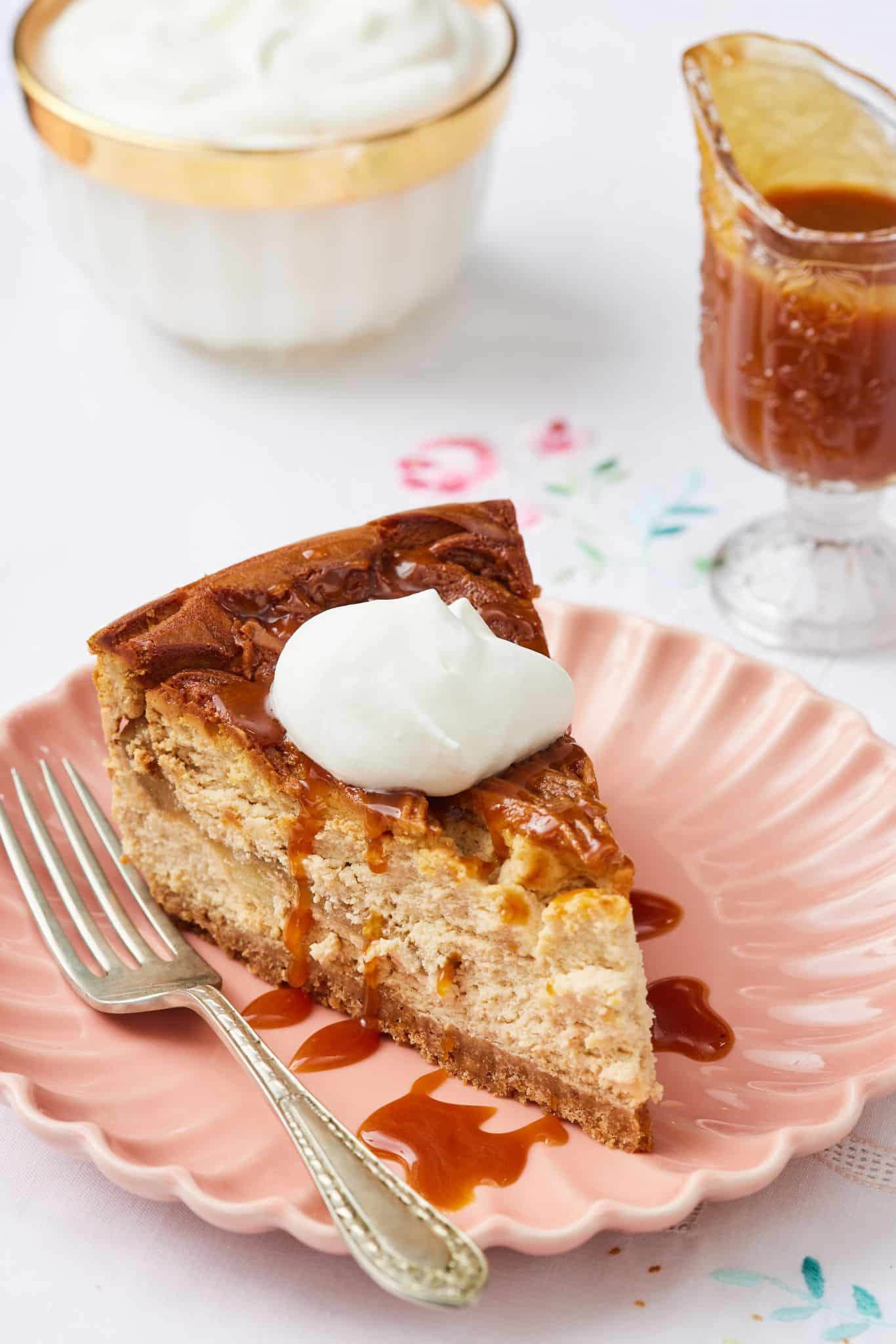 Caramel Apple Cheesecake19 A slice of Caramel Apple Cheesecake is served with whipped cream and caramel on the side.