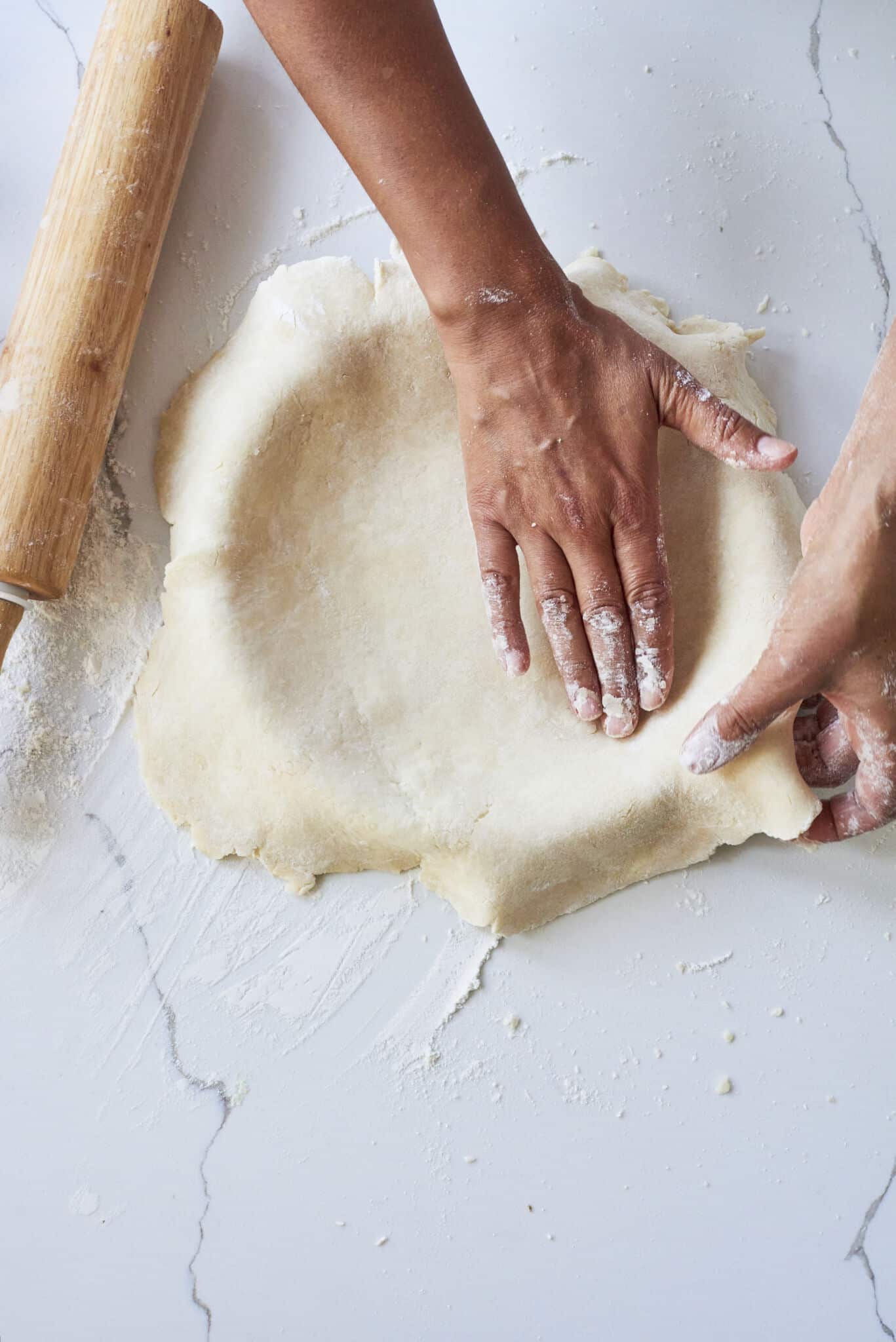 An overhead image of the bottom pie crust being placed into a pie pan.