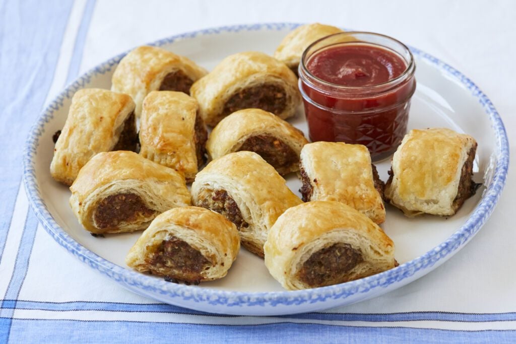 Homemade Sausage Rolls on a plate with tomato sauce