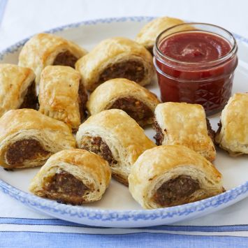 Homemade Sausage Rolls on a plate with tomato sauce