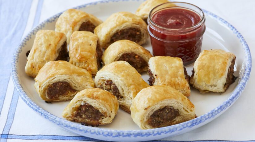 Homemade Sausage Rolls on a plate with tomato sauce