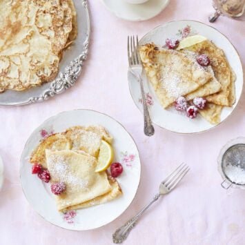 Pairing my soft crepes with slices of lemon and fresh berries dusted with powdered sugar. It makes for a delicate breakfast.