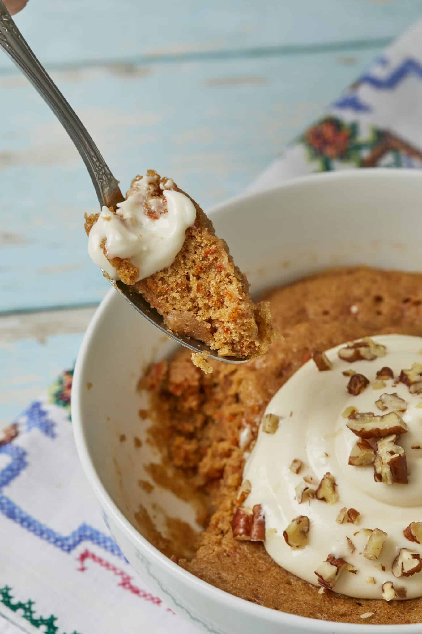 A spoonful of a Carrot Cake Bowl recipe with cream cheese frosting and walnuts