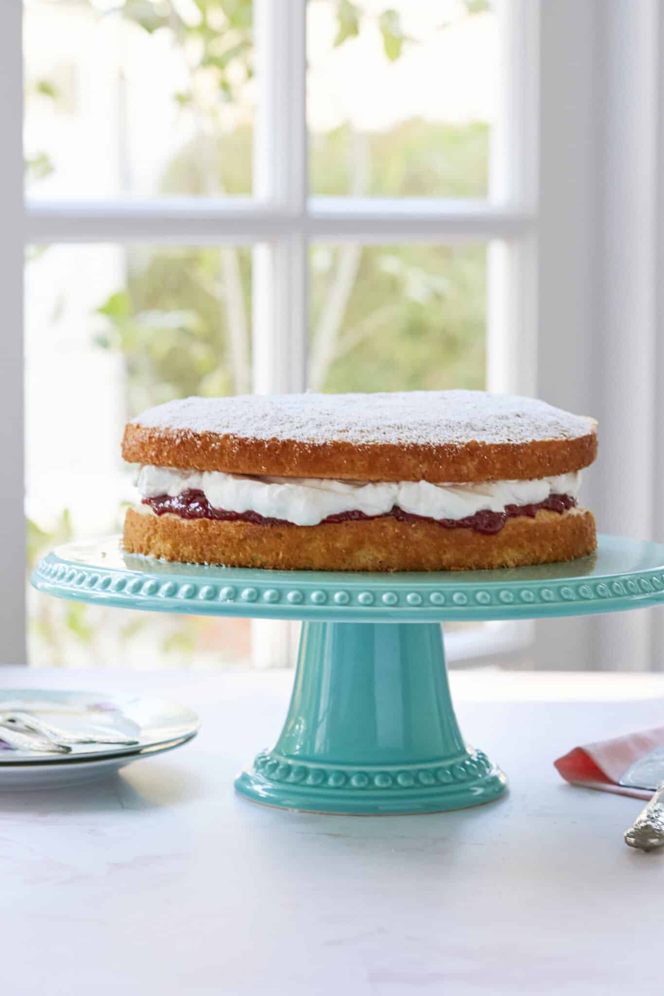 Classic Victoria Sponge Cake Recipe- filled with whipped cream strawberry jam powdered sugar. 
