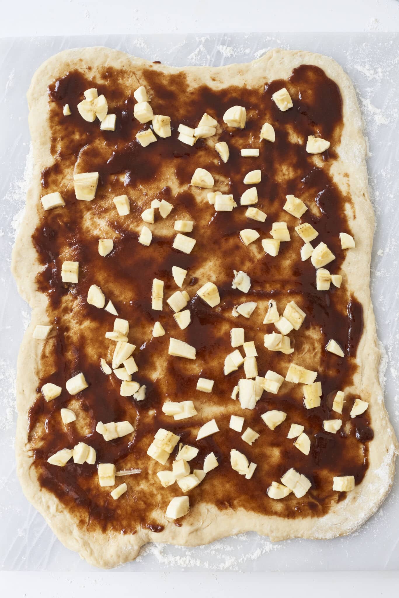 Diced fresh bananas are evenly scattered on top of the deep amber color filling over the dough. 