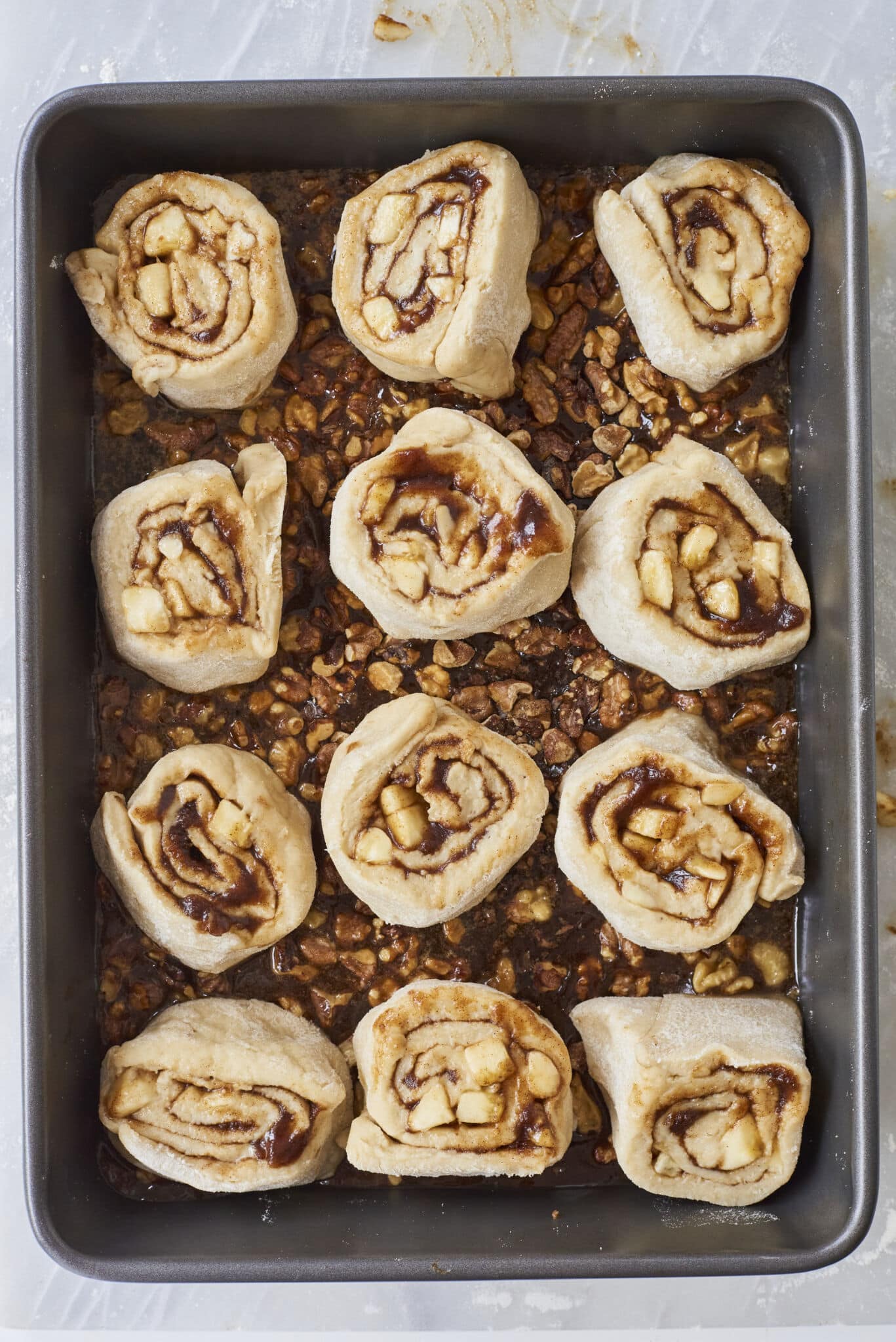 The cut-out rolls are placed on top of toasted walnut caramel sauce in the baking pan, ready for the final proofing. 