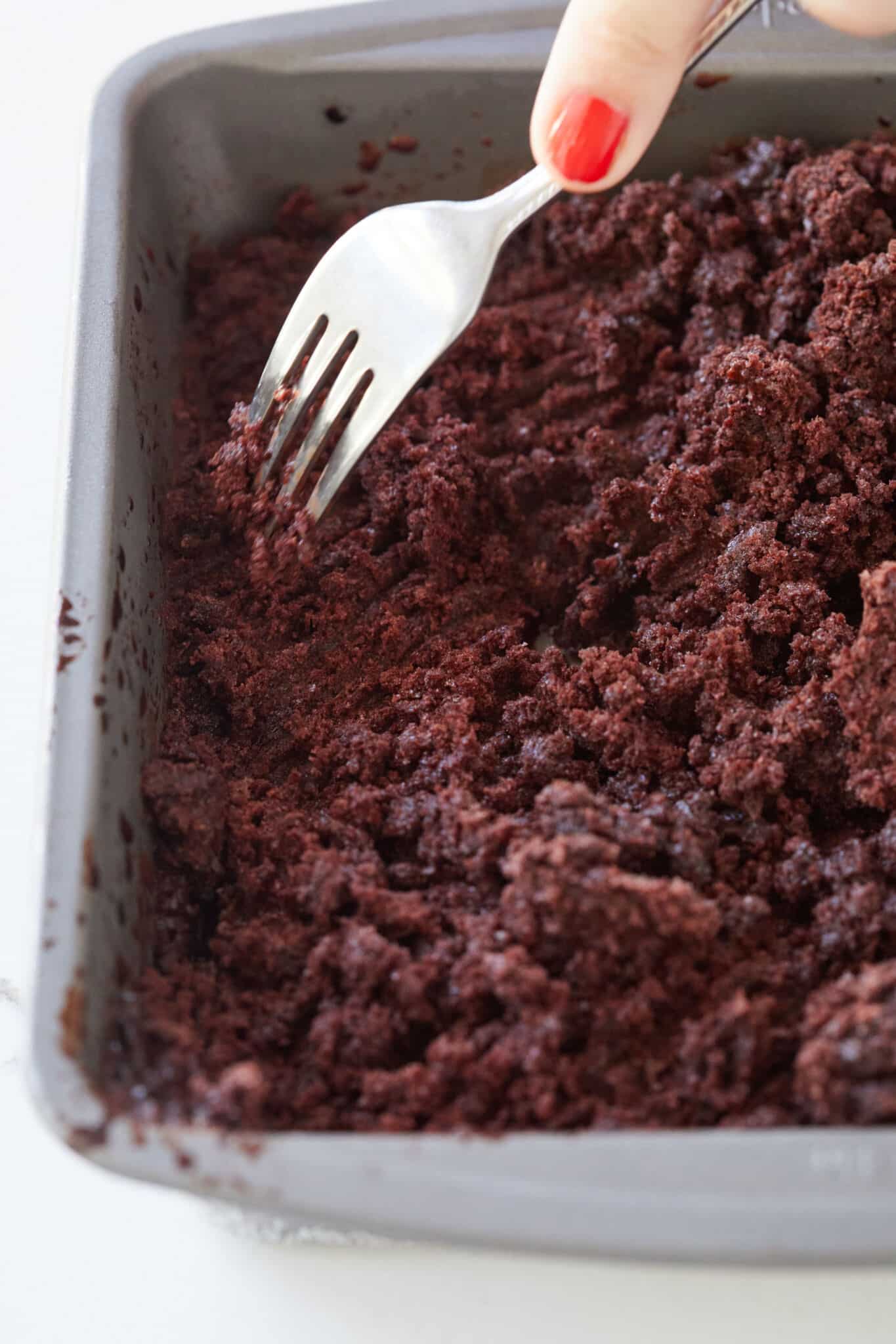 Step-by-step instructions on how to make chocolate granita: use a fork to crape the frozen chocolate mixture and repeat until it has fully formed into ice shards.