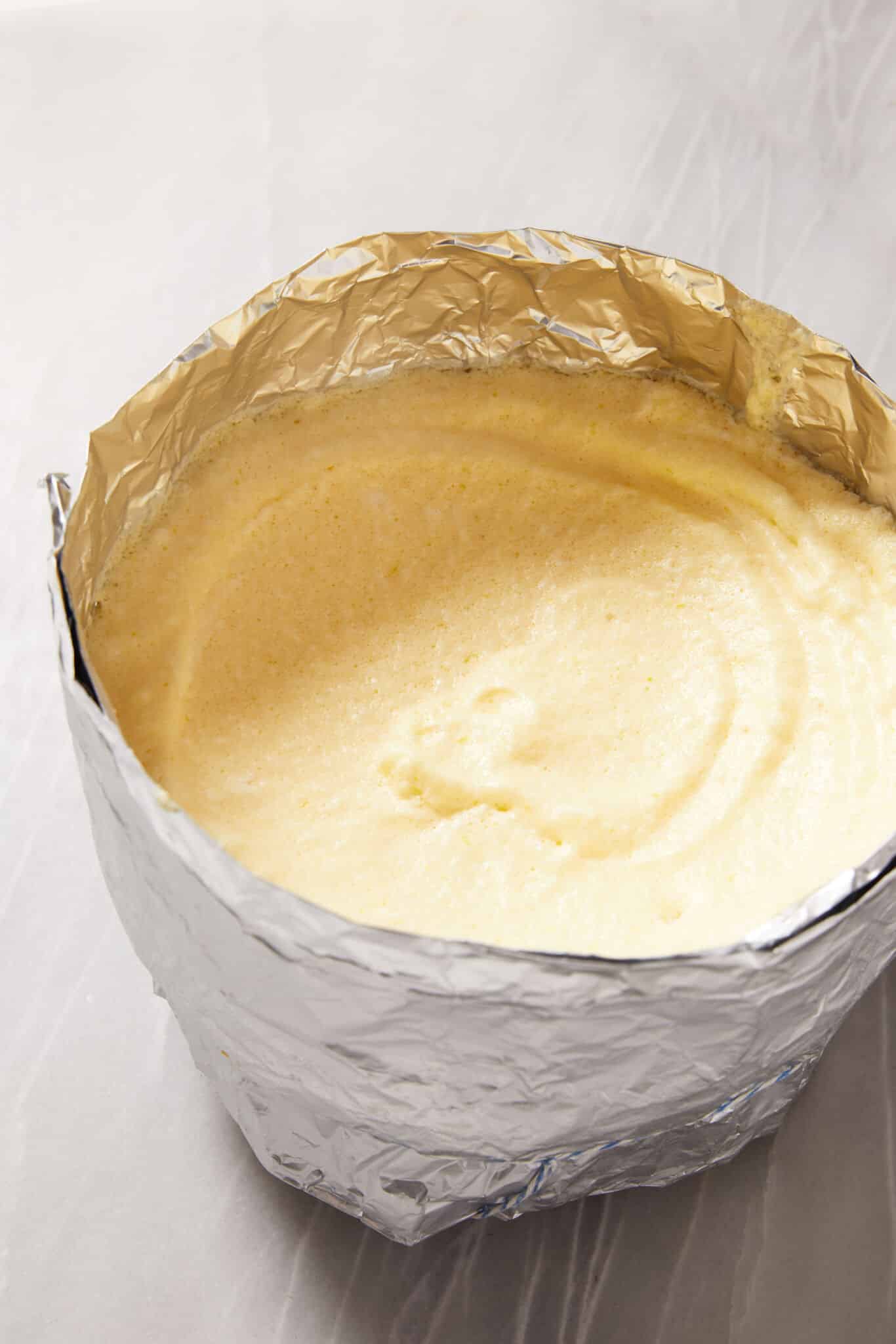 The airy, light and velvety soufflé mixture is poured into the prepared dish with aluminum foil, ready for being transferred to the freezer to set. 