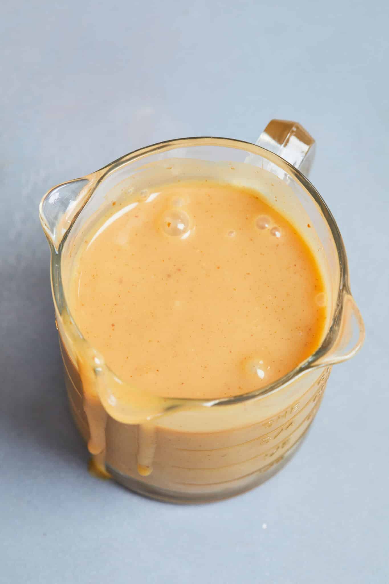 An overhead shot of the smooth peanut butter sauce in a pourable consistency. 