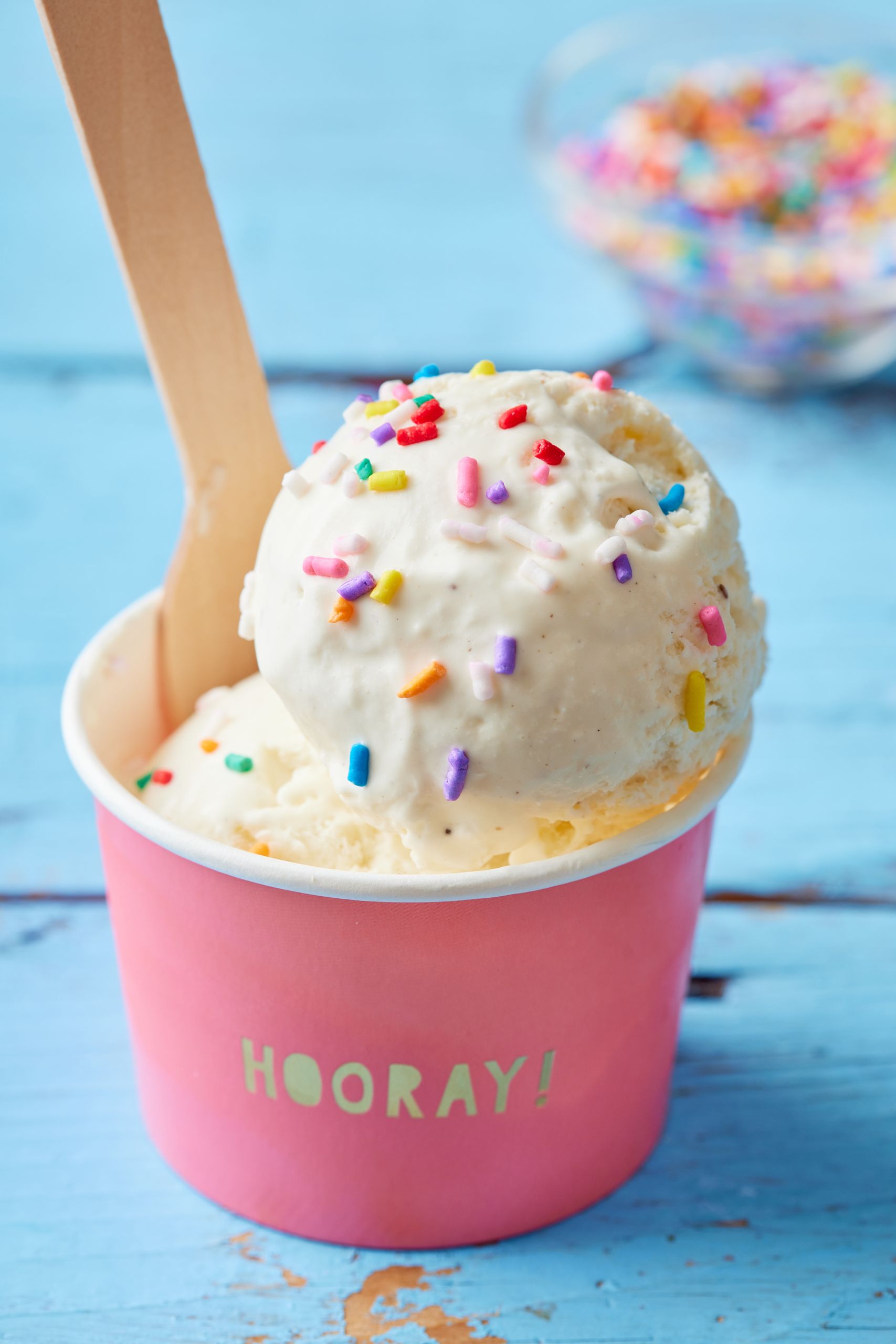vanilla ice cream is served in a paper cup with sprinkles