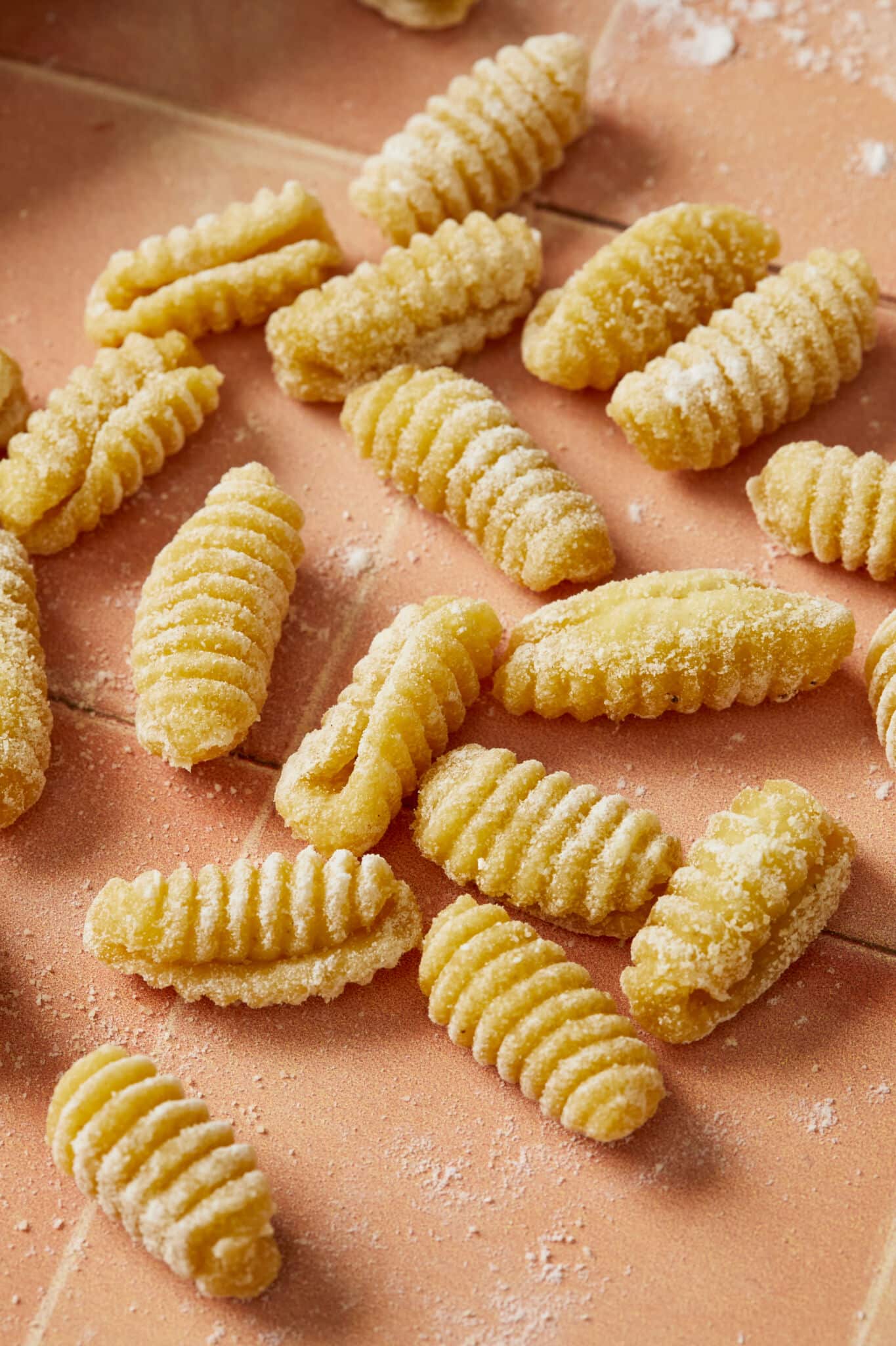 Malloreddus Pasta are shaped into small, elongated shells with a slightly curved shape with ridges on the outer surface.
