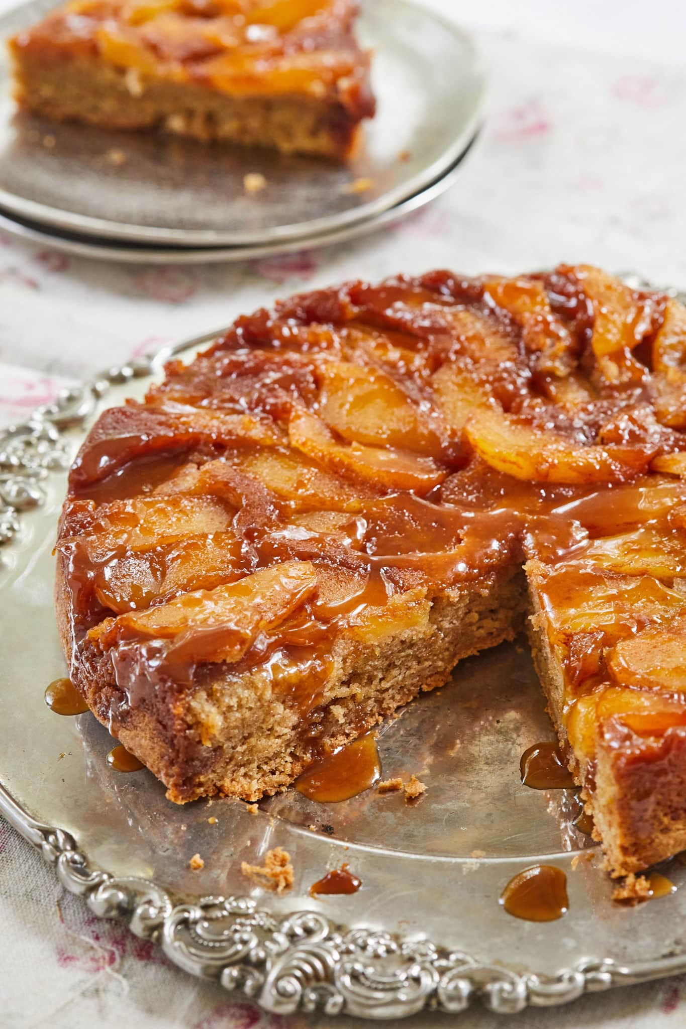 One of the prefect Fall Recipes is Decadent Caramel Apple Upside Down Cake, which is baked golden brown and served on a big platter with one slice cut off and served on a small plate. It's covered with sticky glossy caramel sauce, underneath is slices of tender baked apples, with soft moist cake at the bottom. 