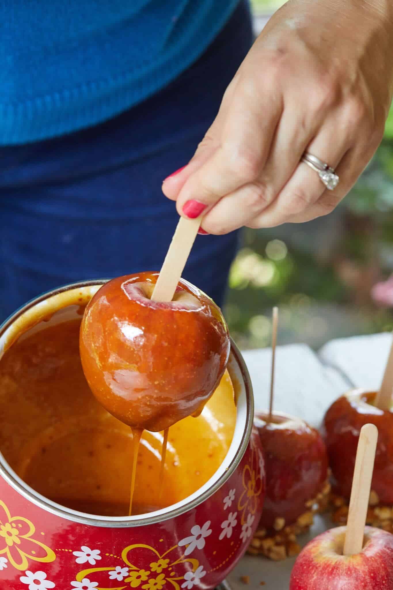 Chewy Caramel Apples have just come out of silky, glossy, and rich caramel sauce from a red fondue pot with yellow and white flowers. It's well coated with caramel all around and is ready to be decorated with toasted peanuts. It holds the most fond memories among fall recipes. 