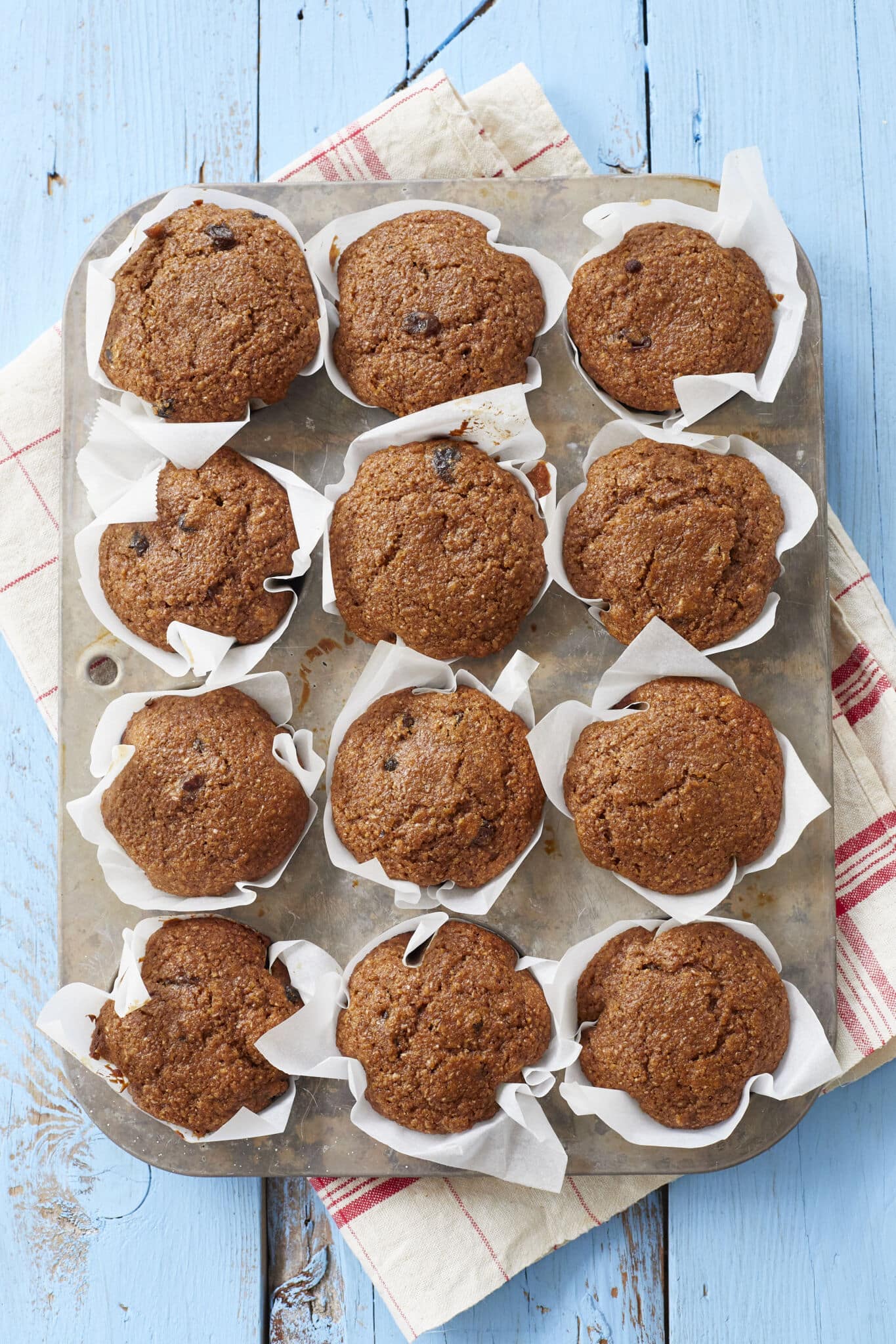 Healthy Bran Muffins are baked perfectly in liners in the muffin tin. They look moist, soft and packed with raisins. 