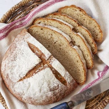 Joululimppu (Finnish Christmas Bread) is a spiced, subtly sweet rye bread and is baked in a round shape scored cross on top. It's dusted tight flour and sliced in a basket lined with a kitchen towel.