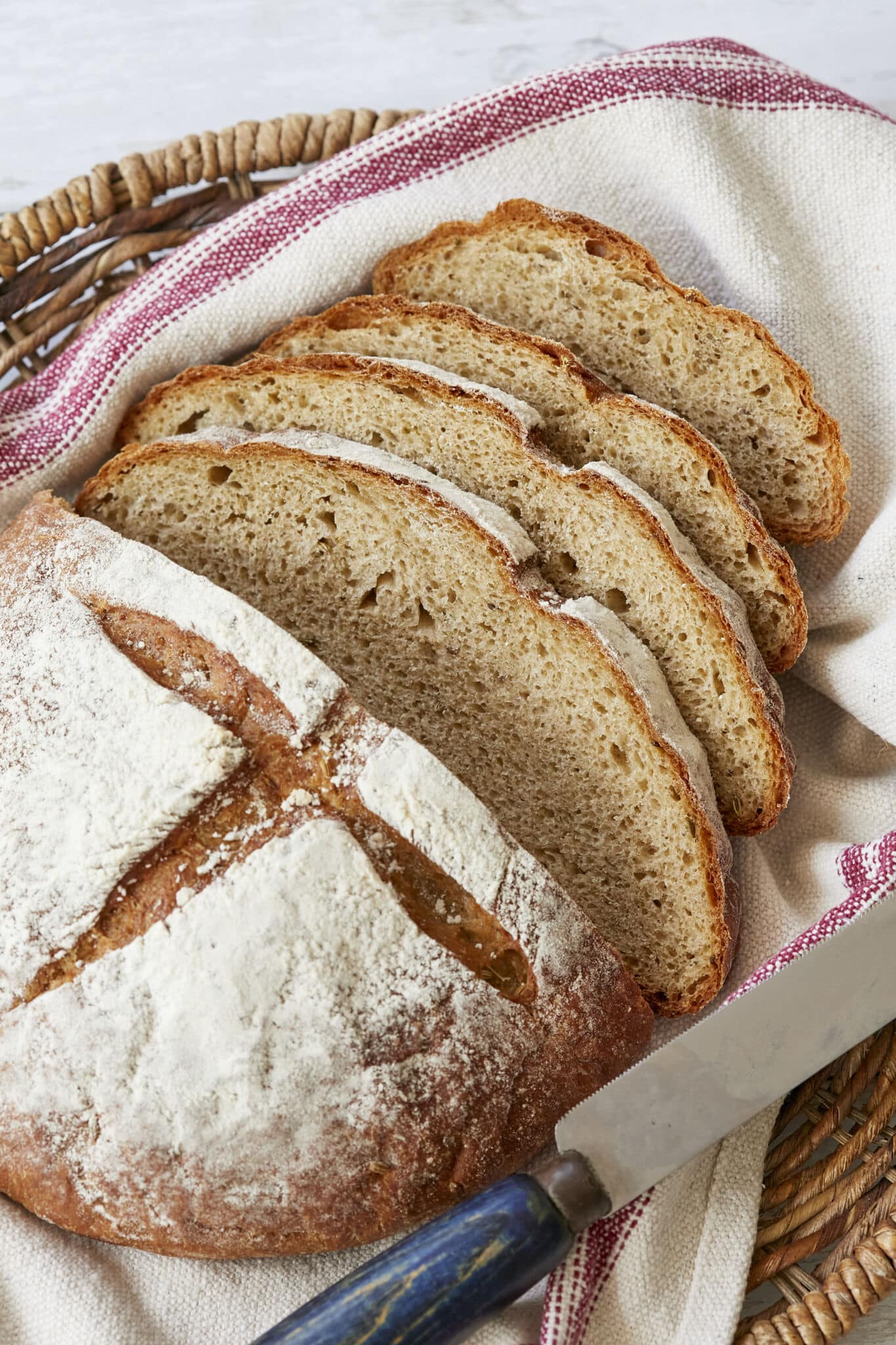 Joululimppu (Finnish Christmas Bread) is a spiced, subtly sweet rye bread and is baked in a round shape scored cross on top. It's dusted with flour and sliced in a basket lined with a kitchen towel. 