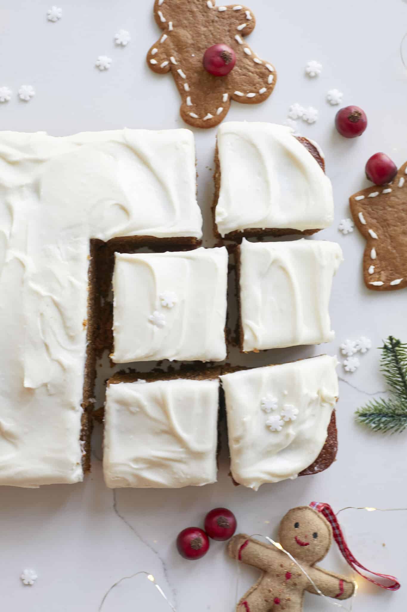 A Perfectly-Spiced Gingerbread Sheet Cake is cut into generous squares and ready for serving. The cake is moist and soft, topped with velvety cream cheese frosting. 