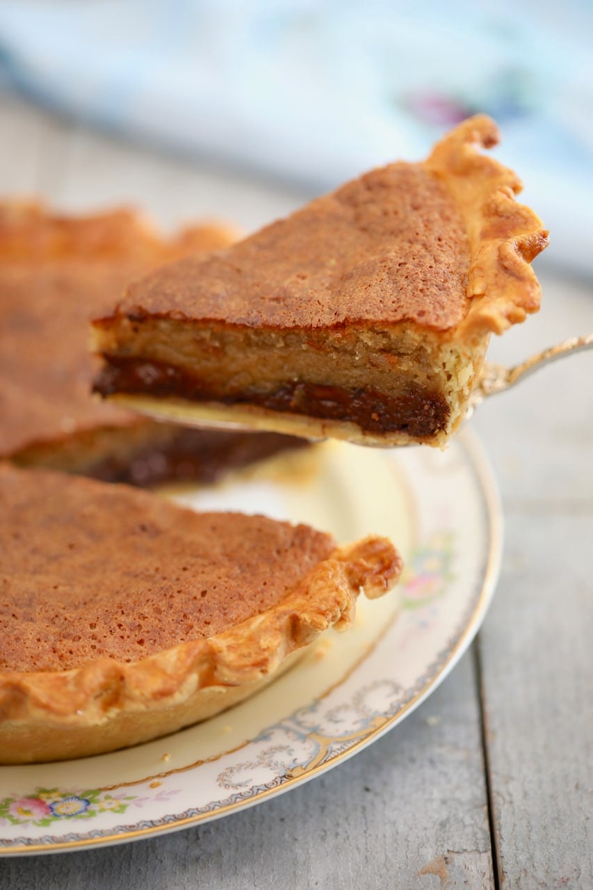 1C5A8584 A side-view of chocolate chip cookie pie, one slice is being lifted away, showing the layers.