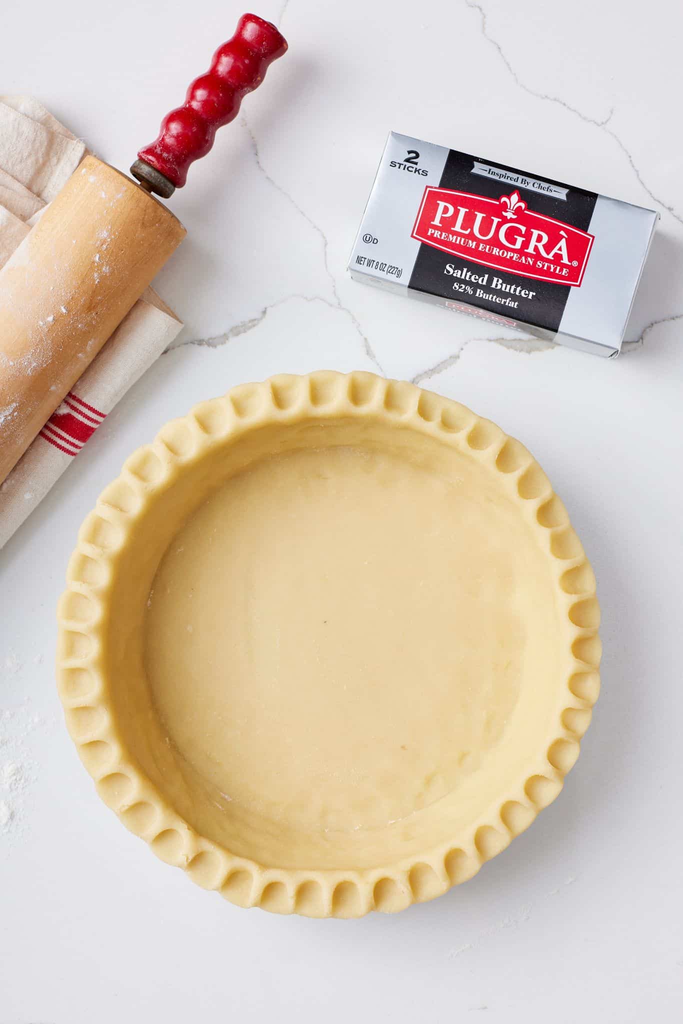 All Butter Pie Crust10 All Butter Pie Crust in the pie pan with a rolling pin and butter stick on the side.