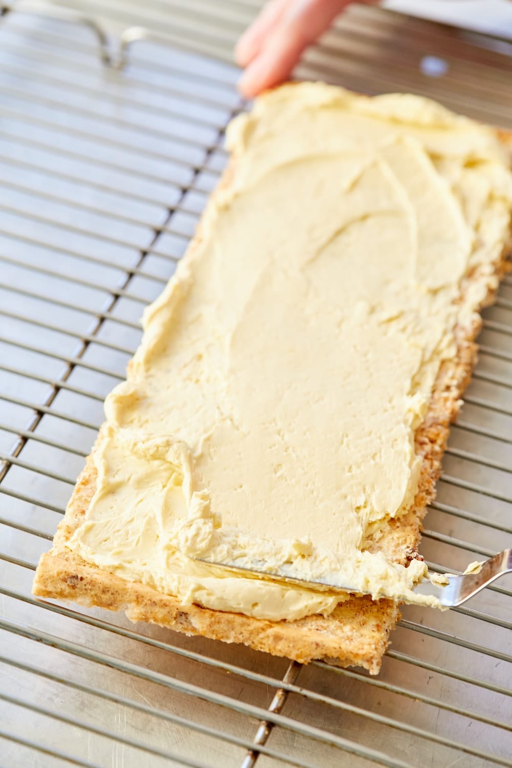Place one layer of cake on a cooling rack over a baking pan. Spread with half of the French buttercream.