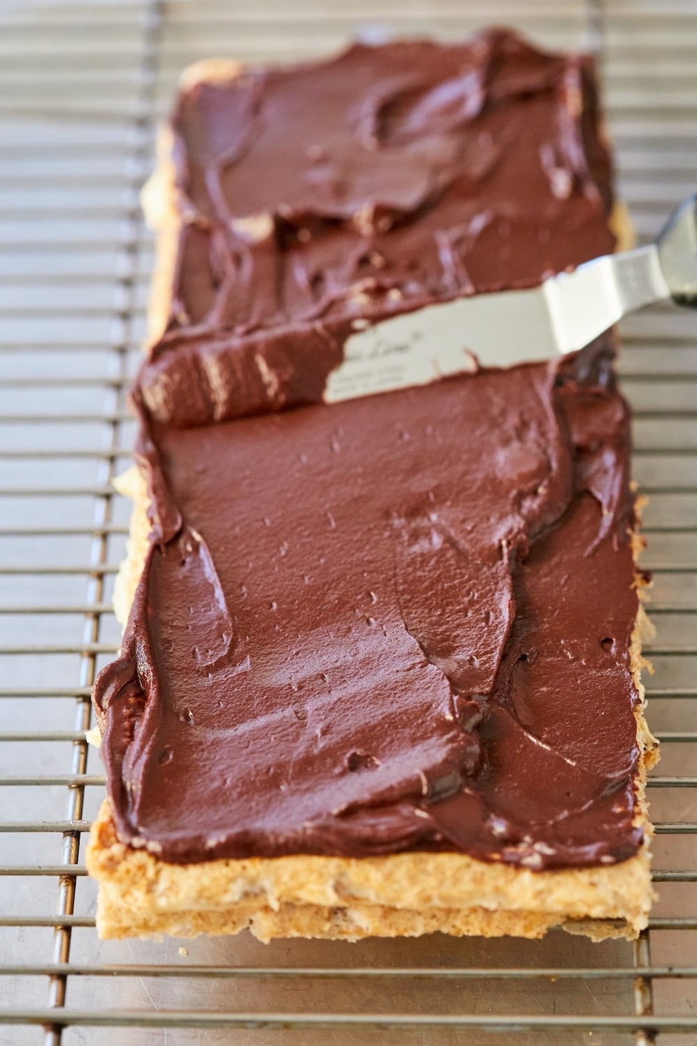 Place a second layer of cake on top of the buttercream and spread ganache over this layer.