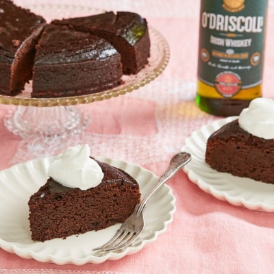 Rich, moist and decadent Irish whiskey Chocolate Cake are sliced and served with whipped cream.