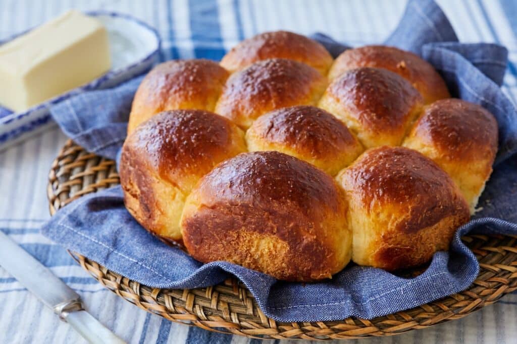 Golden brown and fluffy Japanese Milk Bread (Hokkaido Bread) on the cooling rack. Butter is served on the side.