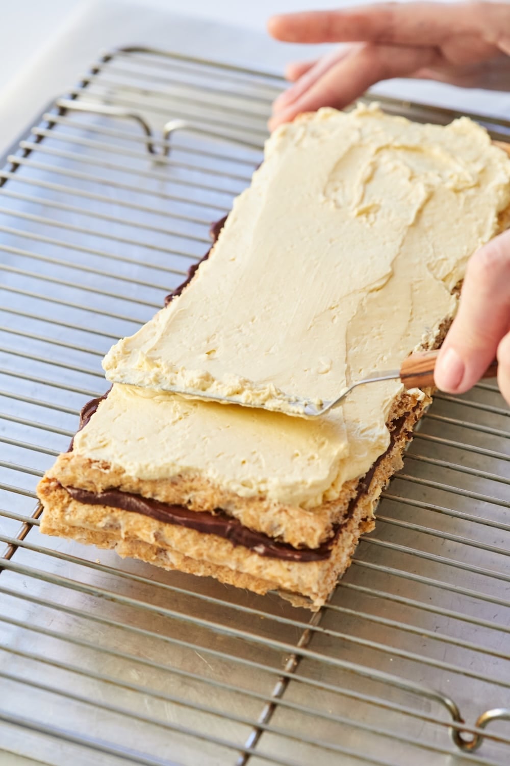Top with a third layer of cake and the remaining buttercream, followed by the final cake layer.