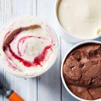 An over-head shot at 3 containers of thick, smooth No-Churn Artisanal Ice Cream in raspberry flavor, vanilla bean flavor, and chocolate flavor.