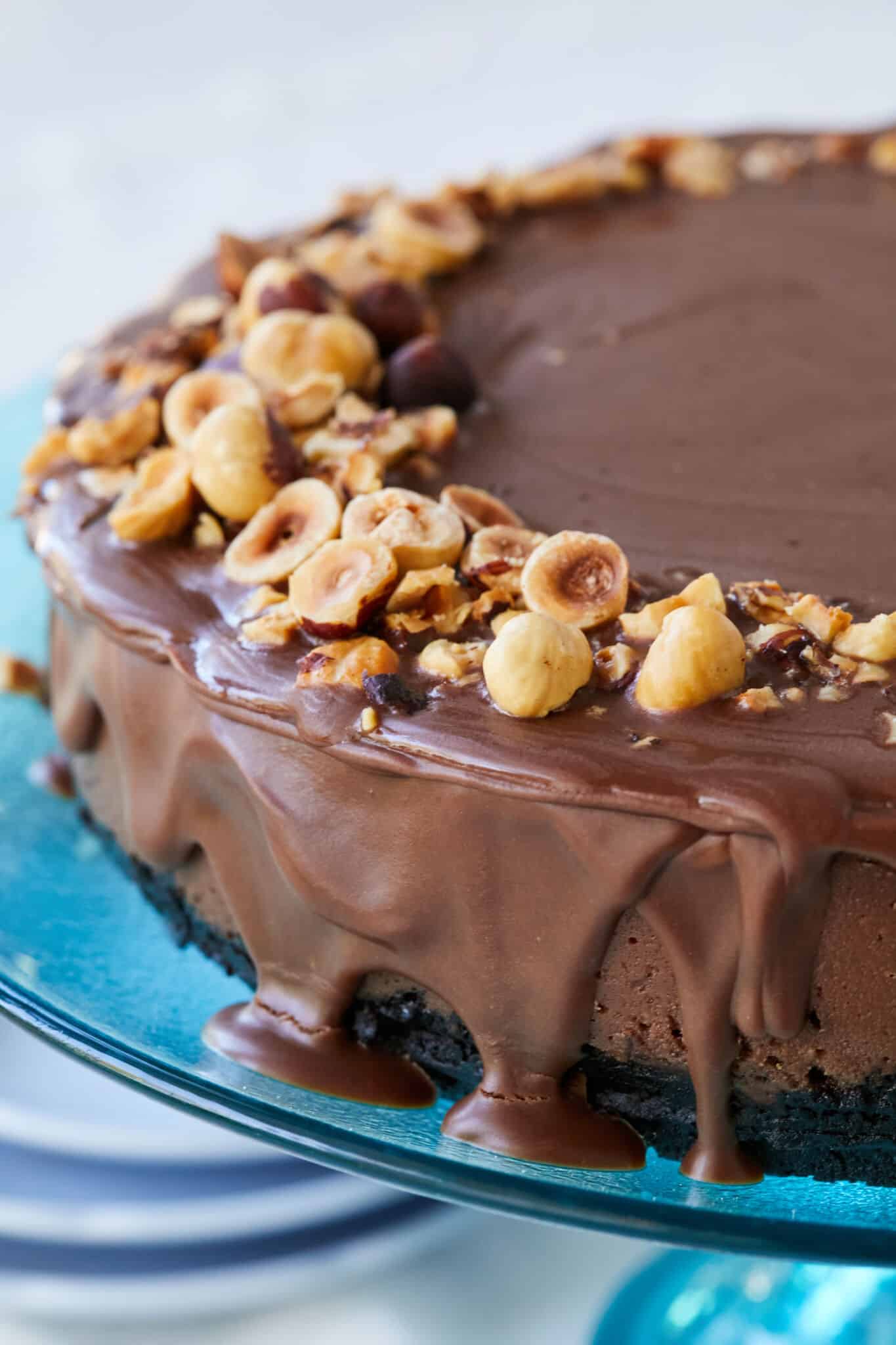 Heavenly Nutella Cheesecake is coated with silky smooth ganache and topped with crunchy toasted hazelnuts. 