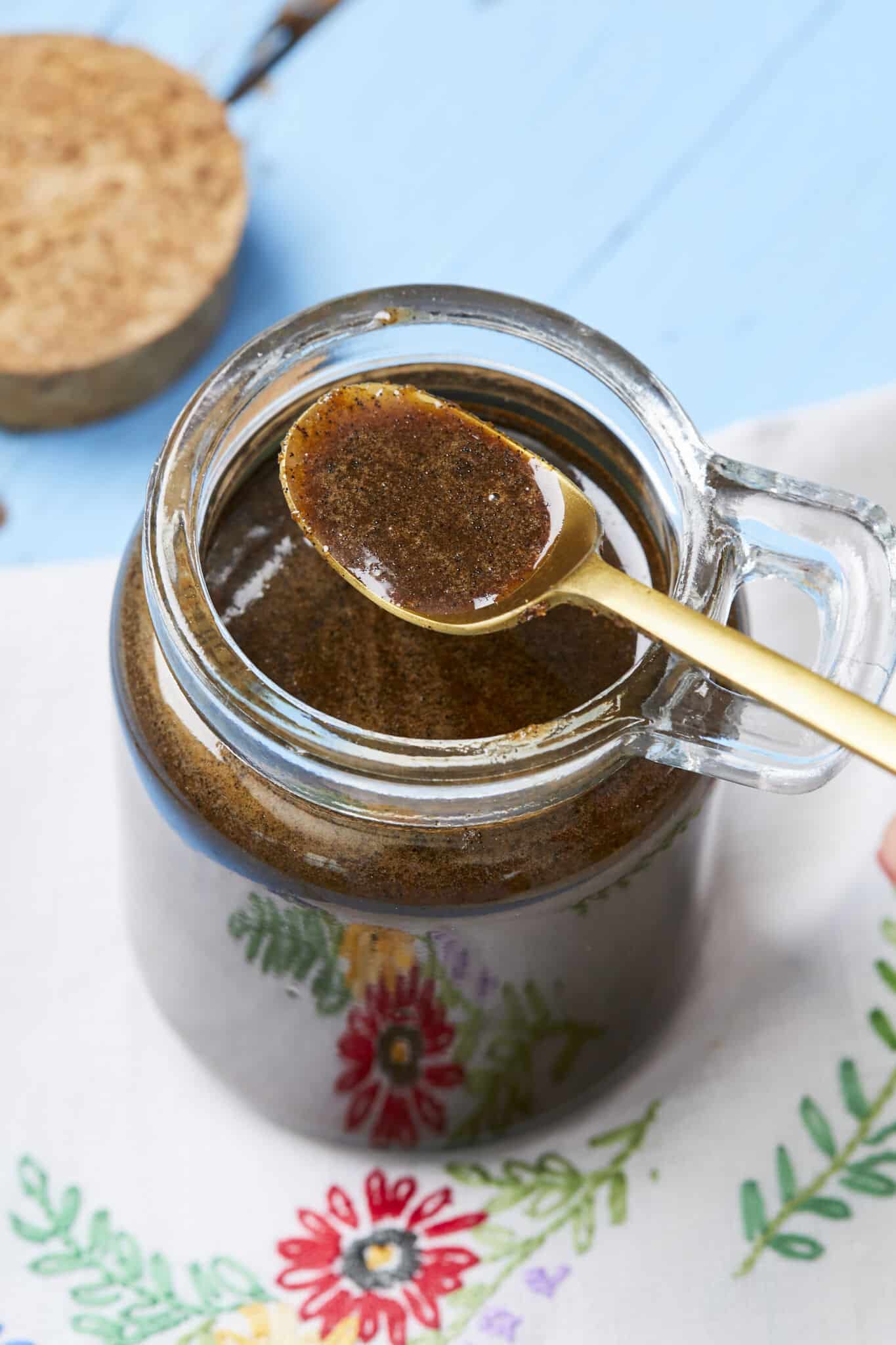 Vanilla bean paste is sotred in a glass jar with a golden colors spoon on top holding some paste to show the consistency and color. Vanilla Bean Paste has a thick and slightly viscous consistency. The vanilla bean seeds give it a speckled appearance, which can be visually appealing in recipes.