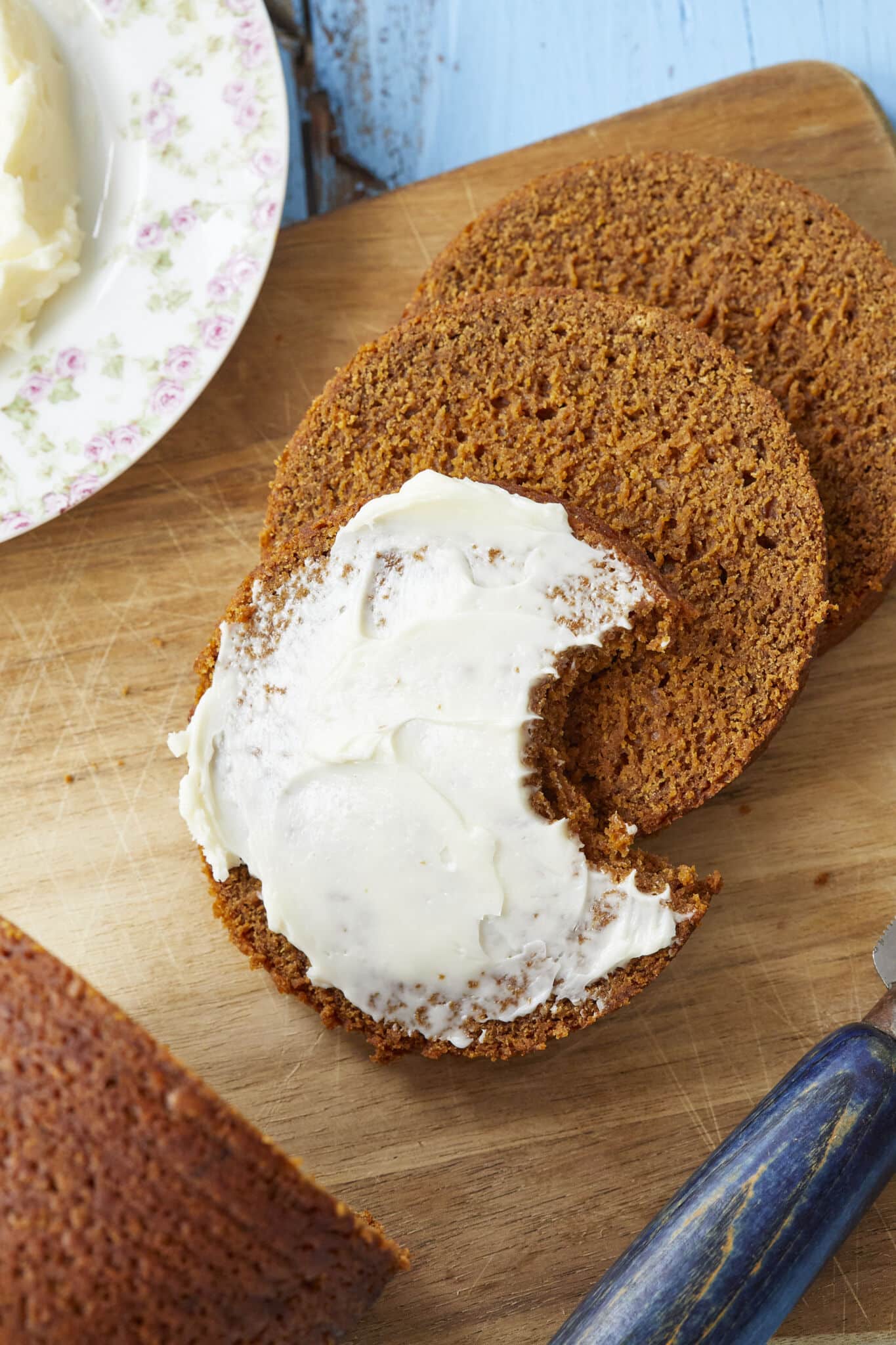 Soft, moist, sweet Boston Brown Bread is sliced and served with butter.