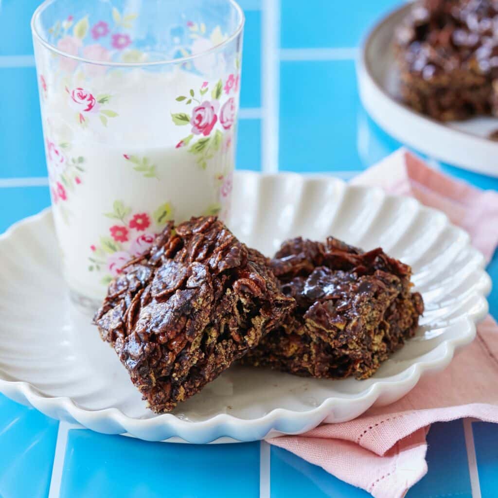 A close-up shot at Easy Chocolate Cracknell baked with crispy cornflakes coated with dark chocolate. They're served with milk.