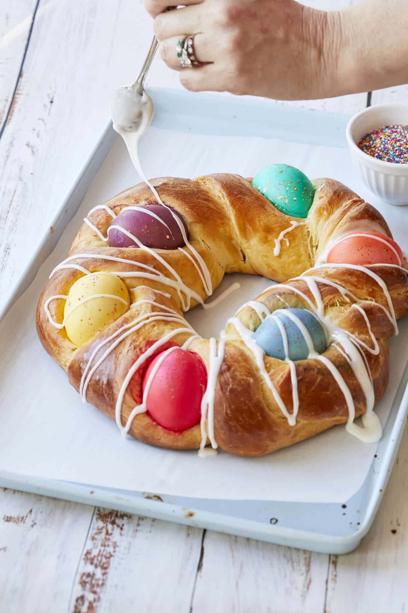 Traditional Italian Easter Bread (Pane di Pasqua) is golden, light and fluffy. It's decorated with colorful Easter eggs and drizzled with icing. 